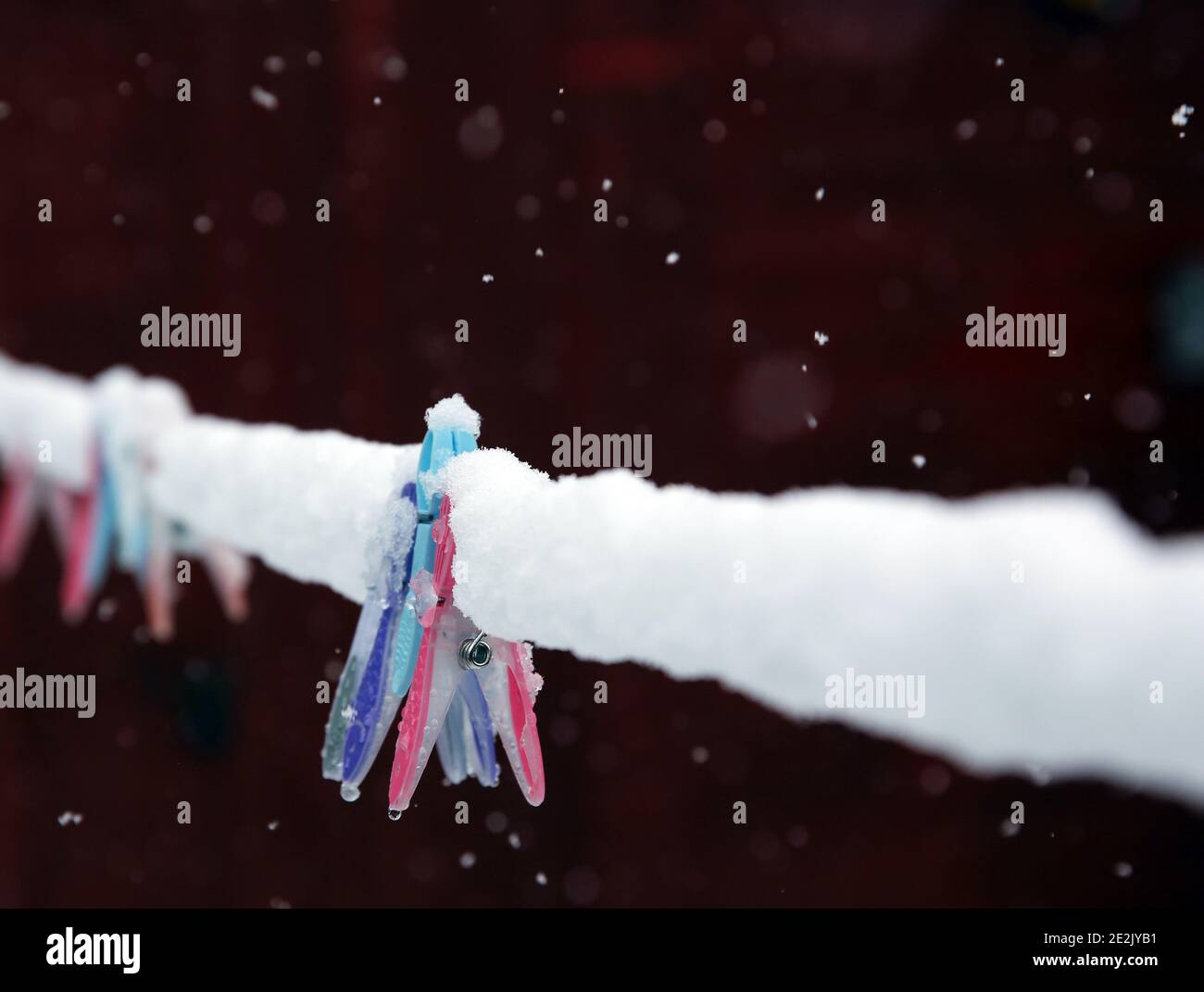 Clothes pegs on a frozen washing line covered in snow. Stock Photo