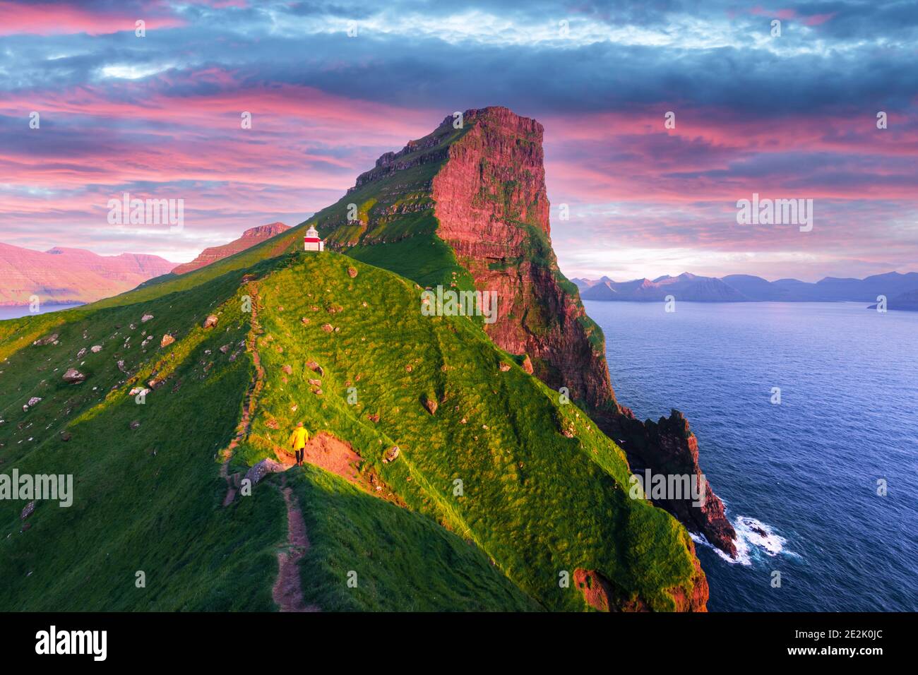 Kallur lighthouse on green hills of Kalsoy island on sunset time, Faroe islands, Denmark. Landscape photography Stock Photo
