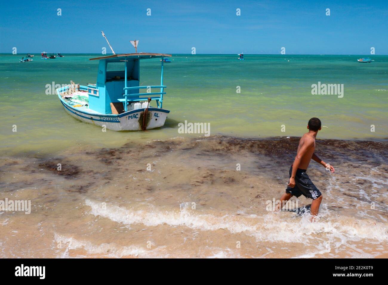 Small fishing boat in the clear waters of Maceió, Brazil Stock Photo