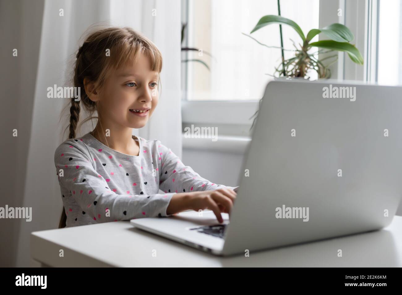 Little girl studying online using her laptop at home Stock Photo - Alamy