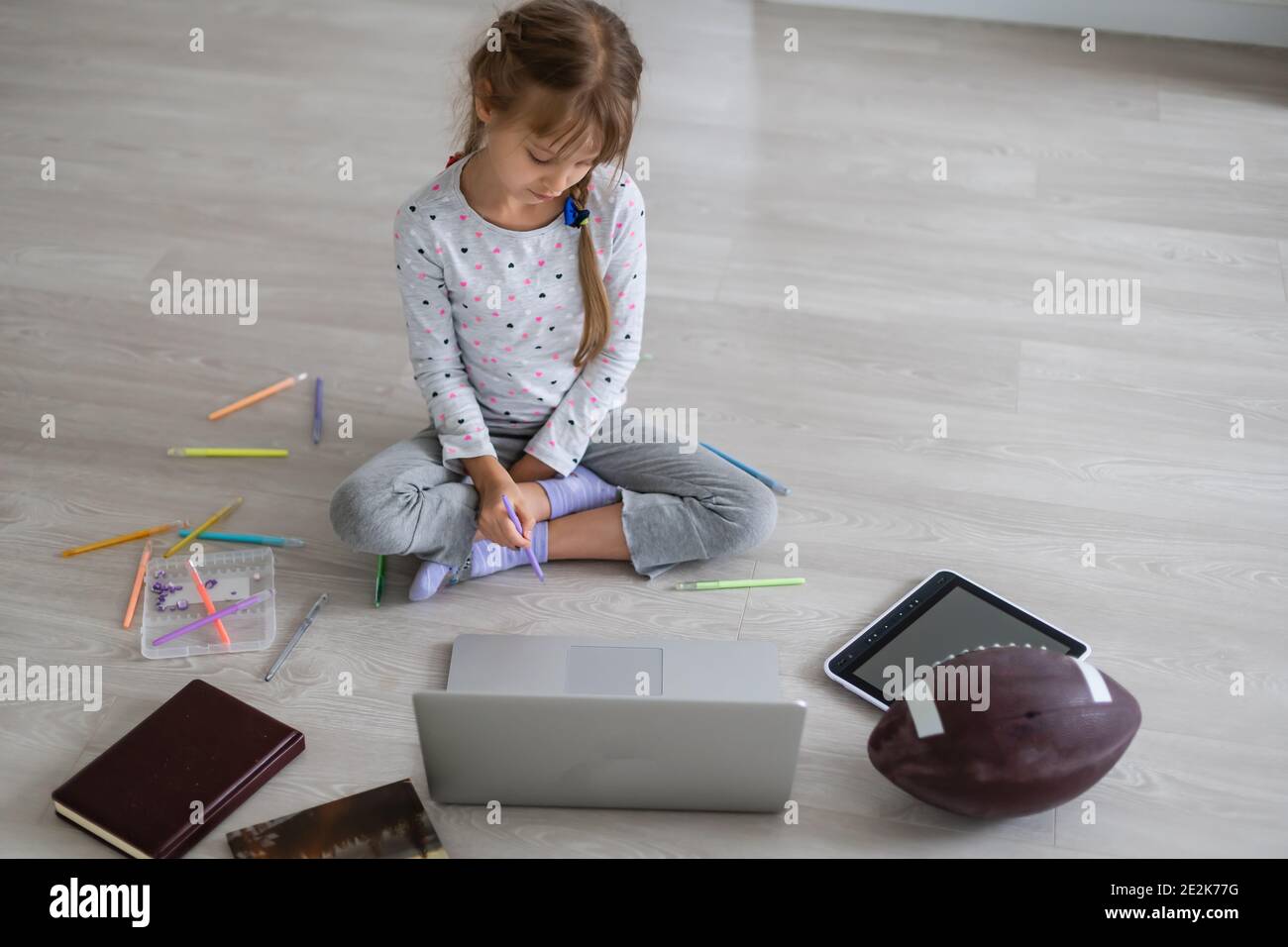 Little girl studying online using her laptop at home Stock Photo - Alamy