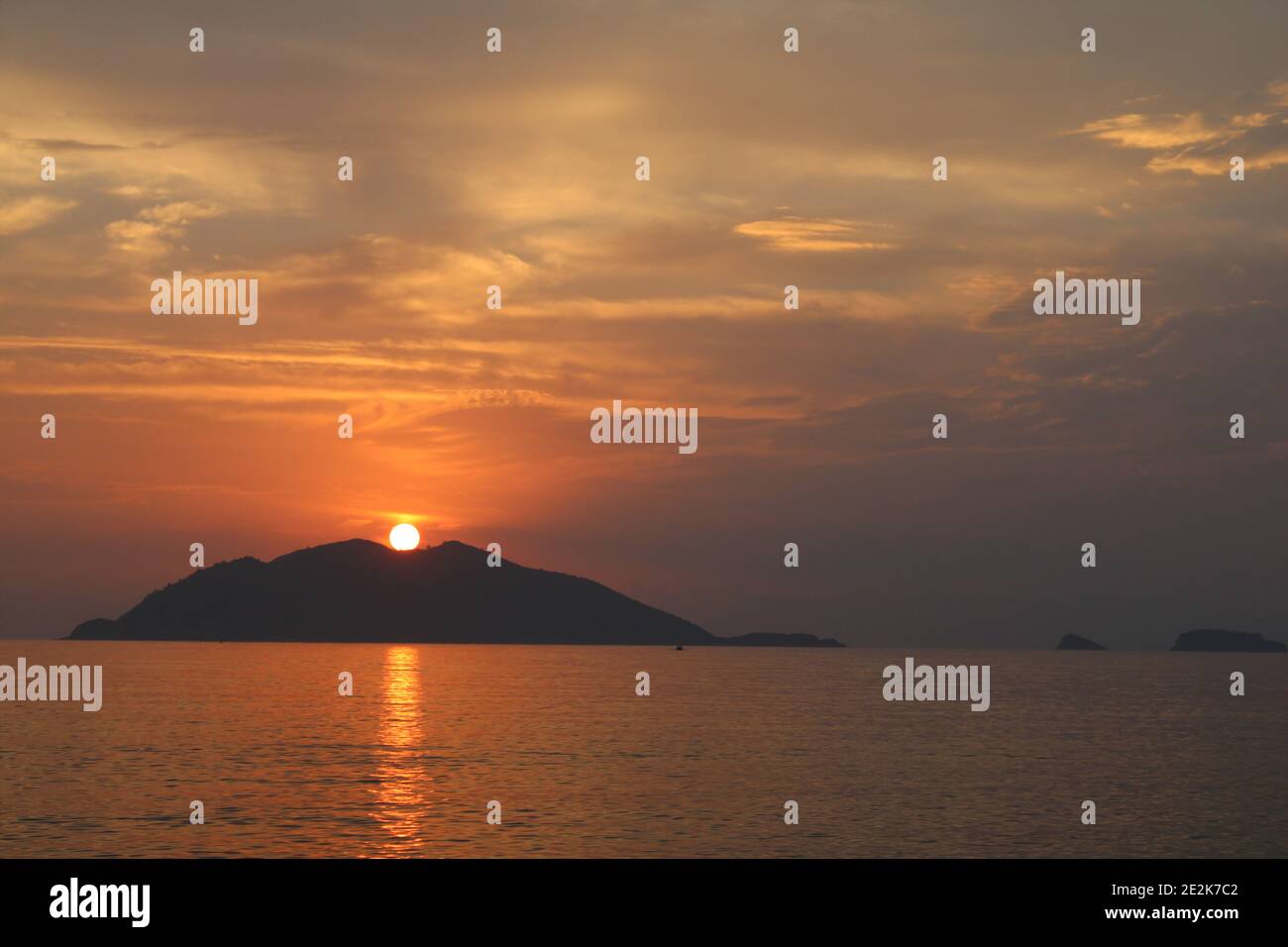 Colorful clouds, sunset, sea and island silhouettes. Orange sun on the ...