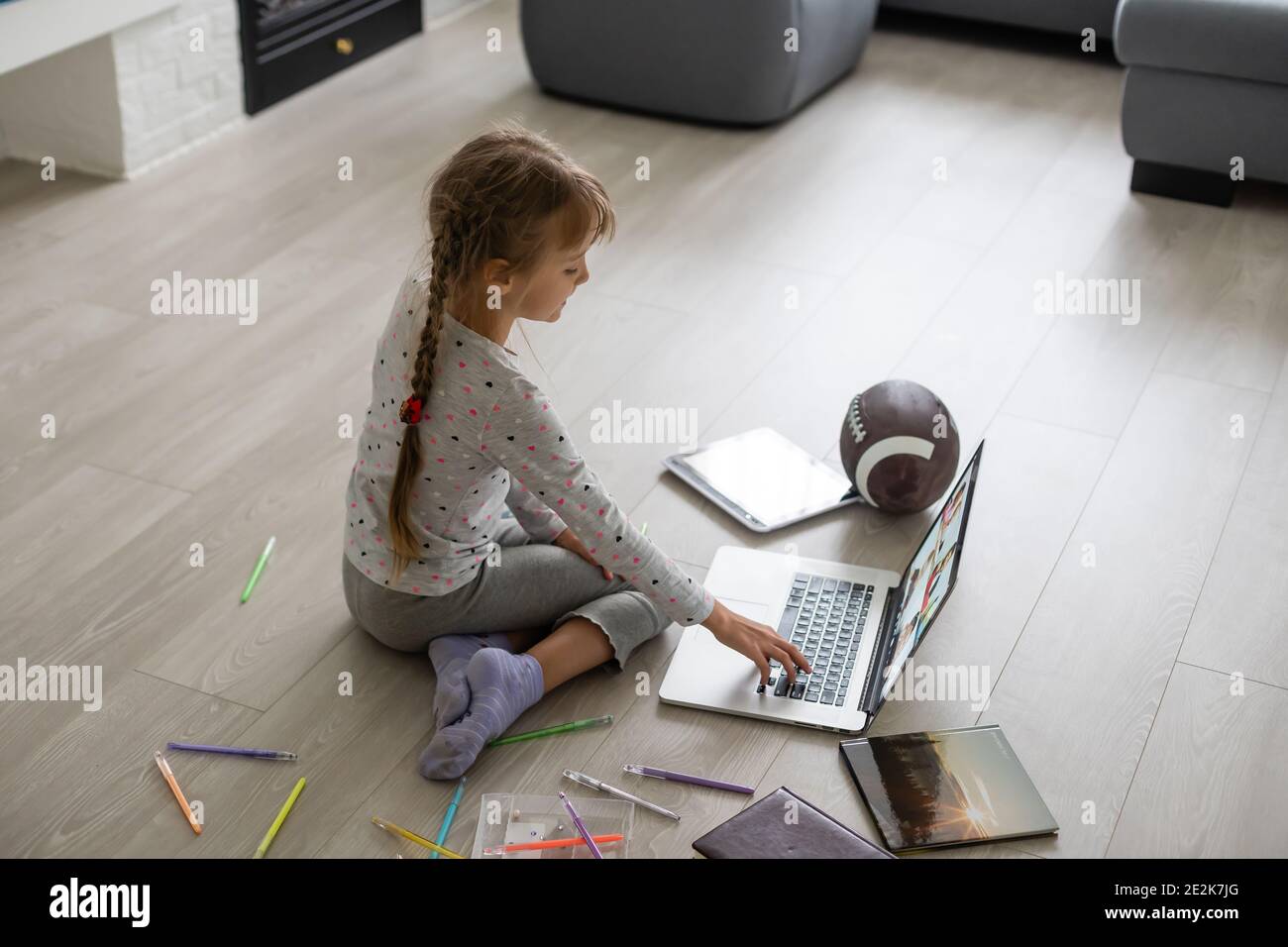 Little girl studying online using her laptop at home Stock Photo - Alamy