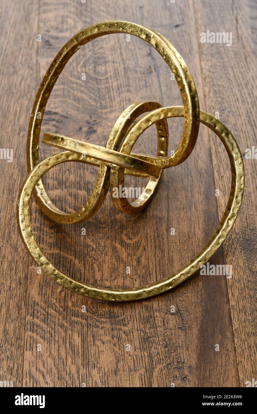Gold metal torus infinity shape on dark hickory wood Stock Photo