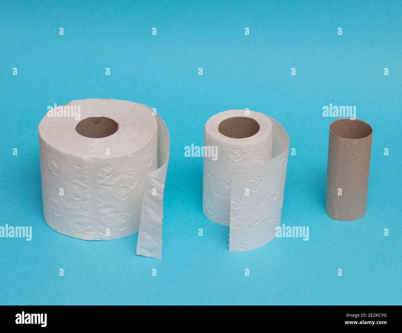 Rolls of toilet paper unrolling against blue background showing usage ...