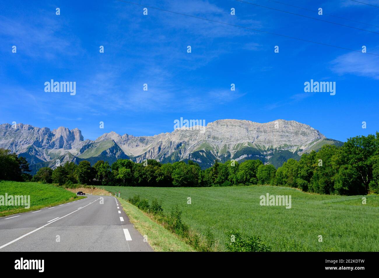 Panoramic view on Breche de Faraut mountain range in French Prealps and green fields in summer Stock Photo