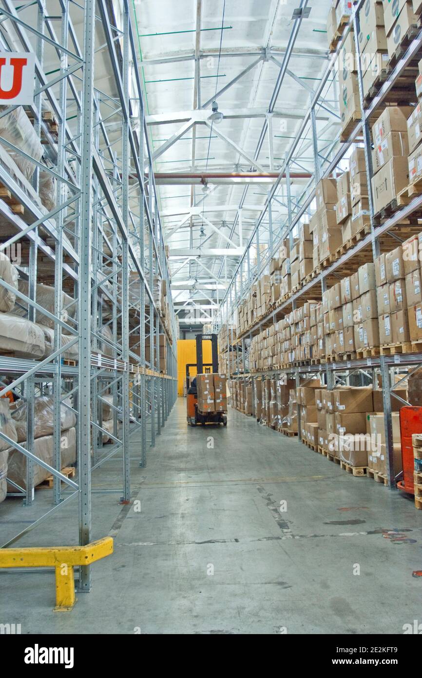 large modern empty warehouse, industrial interior with forklifts. shelves with pallets, boxes, containers and goods Stock Photo