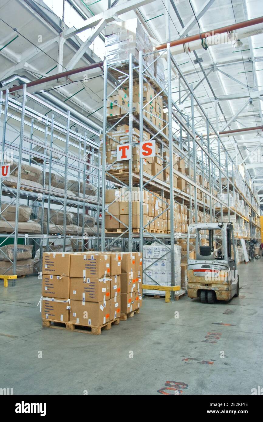 large modern empty warehouse, industrial interior with forklifts. shelves with pallets, boxes, containers and goods Stock Photo