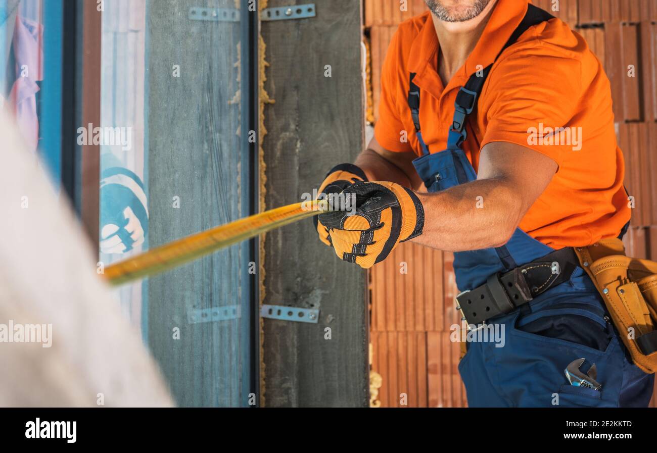 Construction Worker with Measuring Tape in His Hands Taking Sizes ...