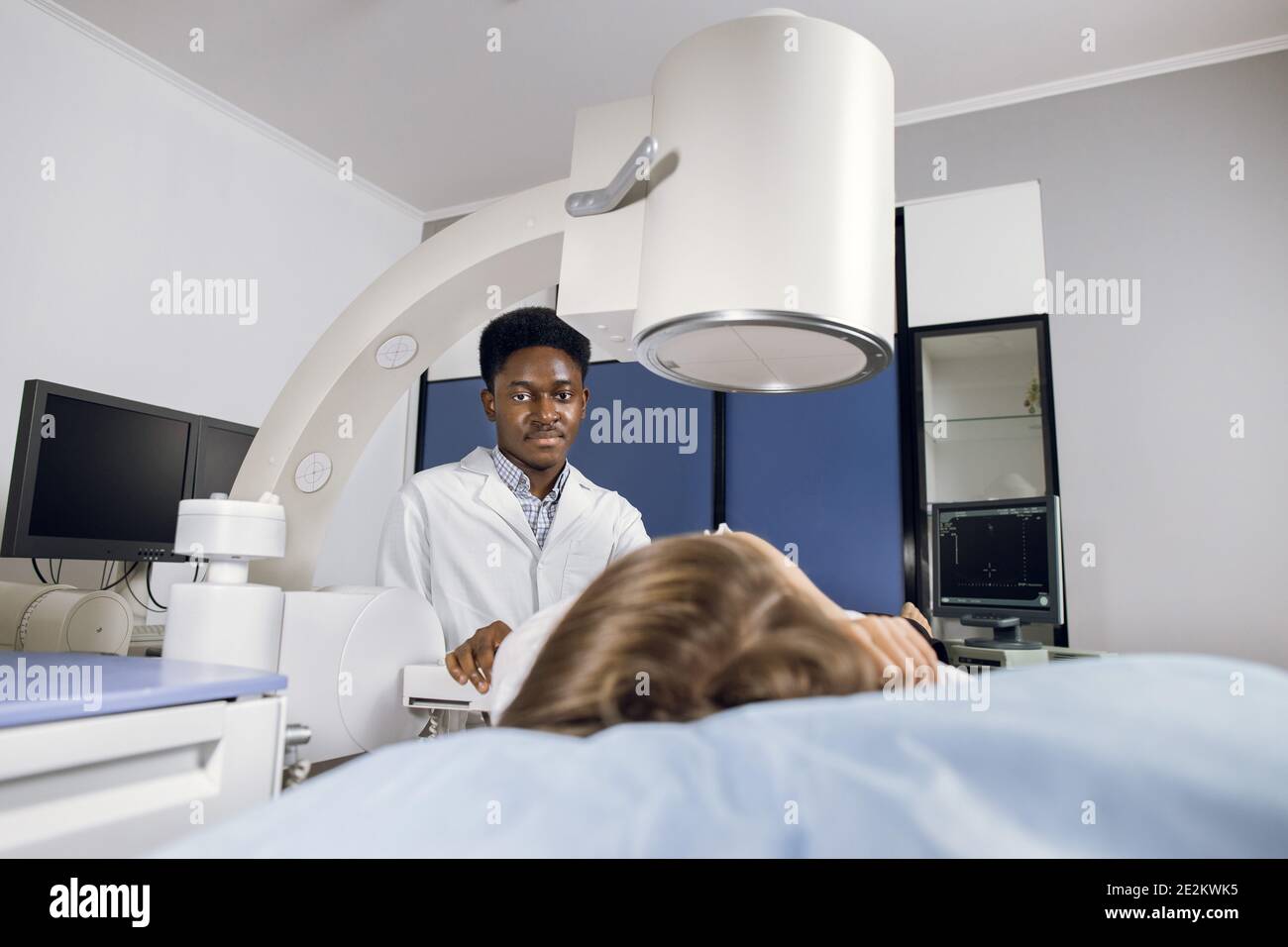 Procedure of extracorporeal shock wave lithotripsy in modern urology medical center. Young African man doctor providing stone treatment or diagnostics Stock Photo