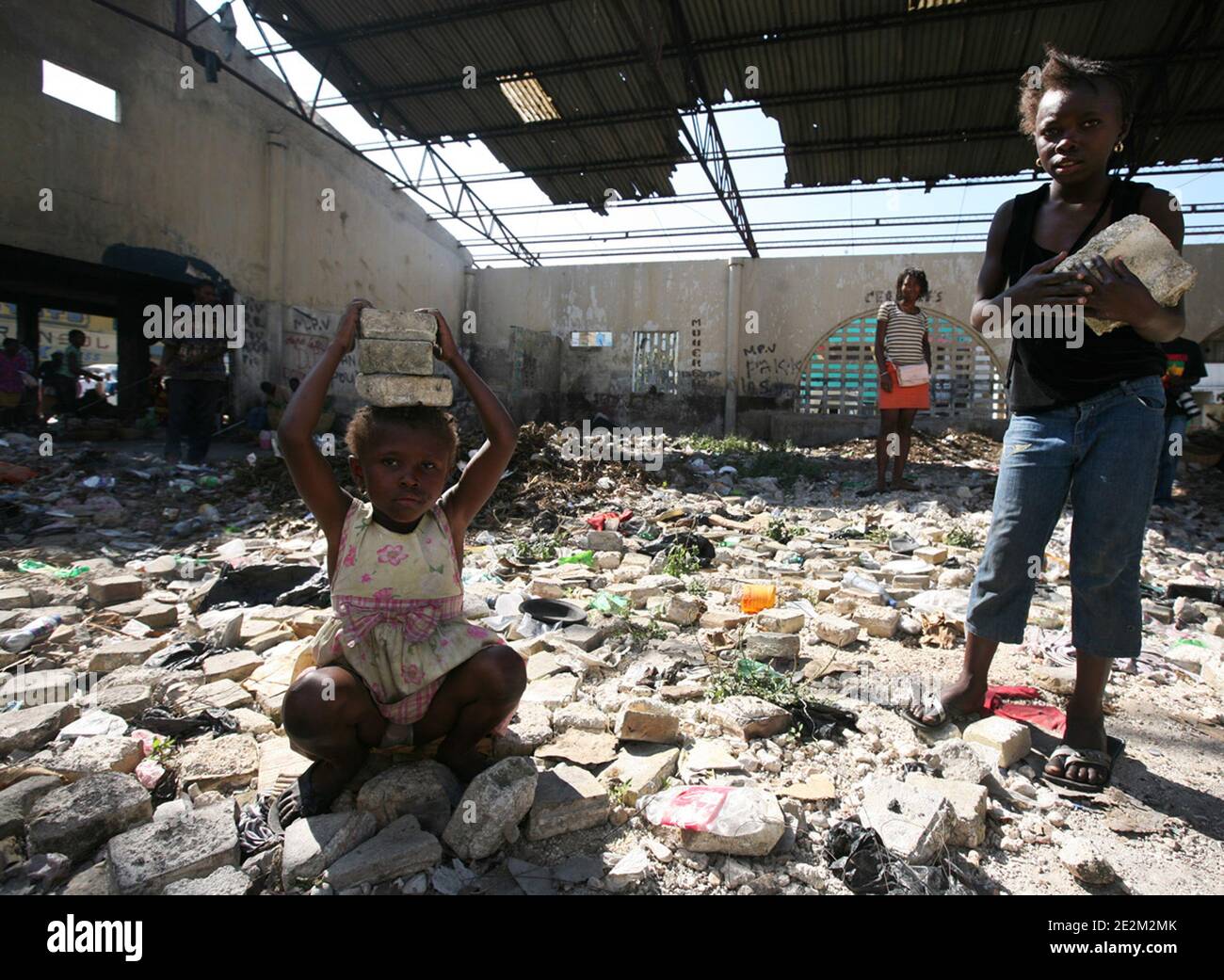 Two young girls help with the removal of rubbage at what used to be the