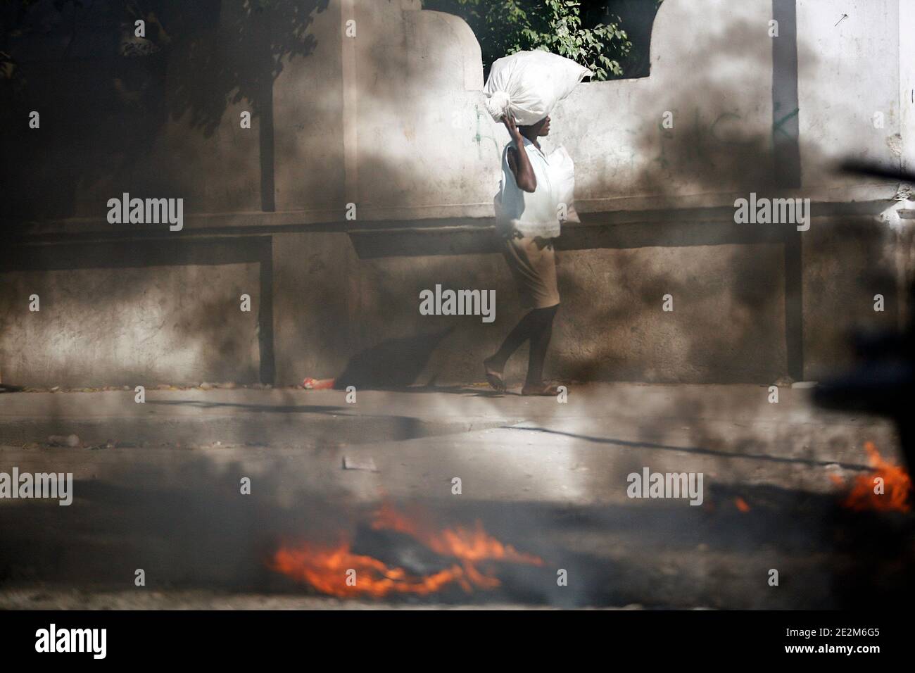 A woman walks by the remains of burning bodies in downtown Portau