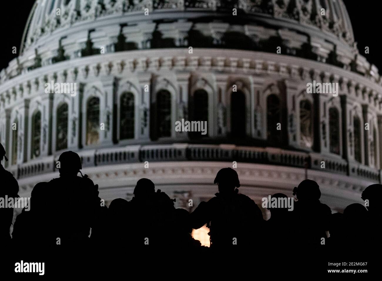 Washington, United States. 13th Jan, 2021. U.S. soldiers and airmen with the National Guard are silhouetted against the Capitol dome as they secure the area for the 59th Presidential Inauguration January 13, 2021 in Washington, DC More than 10,000 national guard troops have been deployed to provide security following the insurrection by Pro-Trump rioters. Credit: Planetpix/Alamy Live News Stock Photo