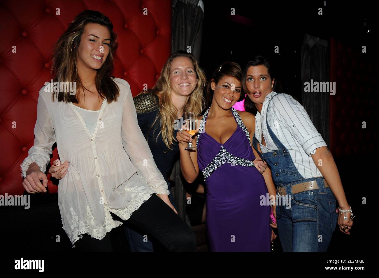 French striptease performer Miss Amal (in violet) poses with contestants of  TV program, 'Moundir, l'aventurier de l'amour', Marie, Clemence and  Stephana during a party held at the Montecristo in Paris, France on