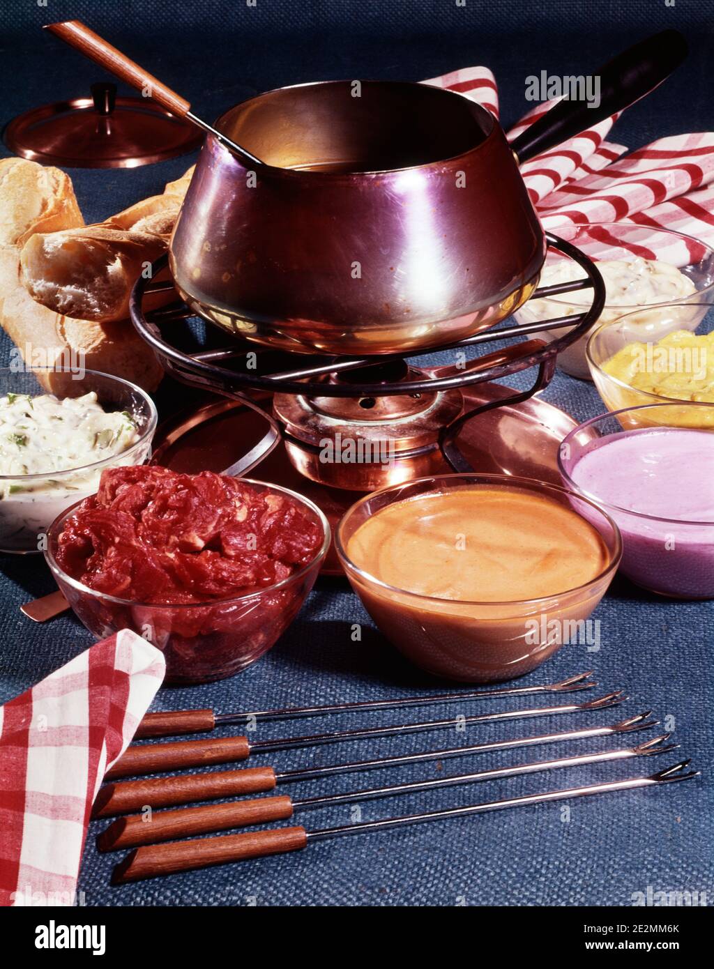 1960s 1970s FONDUE POT ON TABLE WITH BOWLS OF ASSORTED TOPPINGS LONG