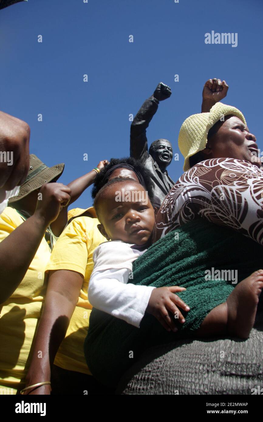 A mother with her child are surrounding a statue of Nelson Mandela during the 20th anniversary of Madiba’s release, in front of the Drakenstein Prison, where, on the morning of the 11th of february 2010, a symbolic walk gathered some of the South-Africa’s most prominent anti-apartheid joined hundreds of people, 70km from Cape Town, South Africa. Photo by Nathalie Gros/ABACAPRESS.COM Stock Photo