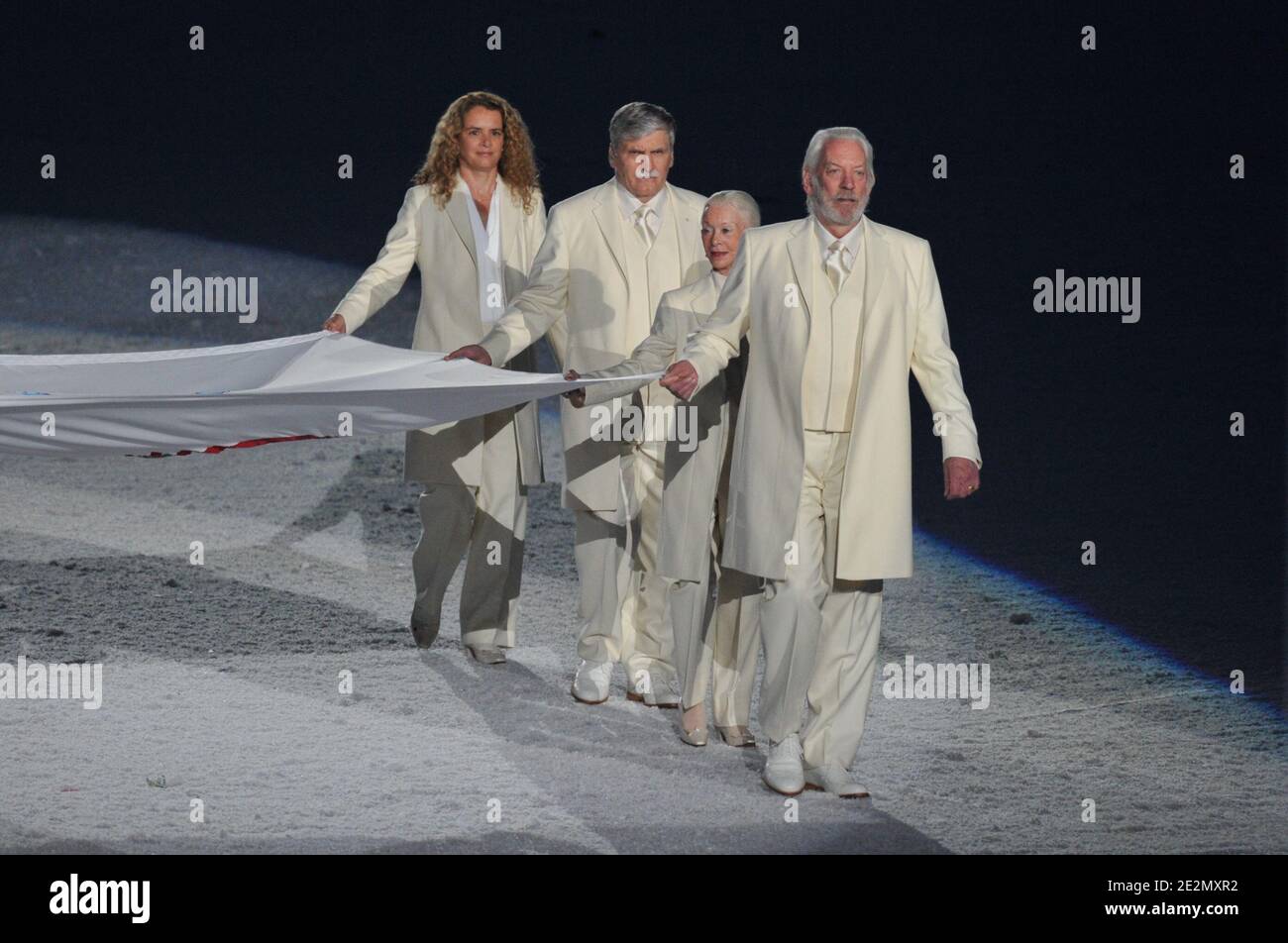 US actor Donald Sutherland carries the Olympic flag during the opening