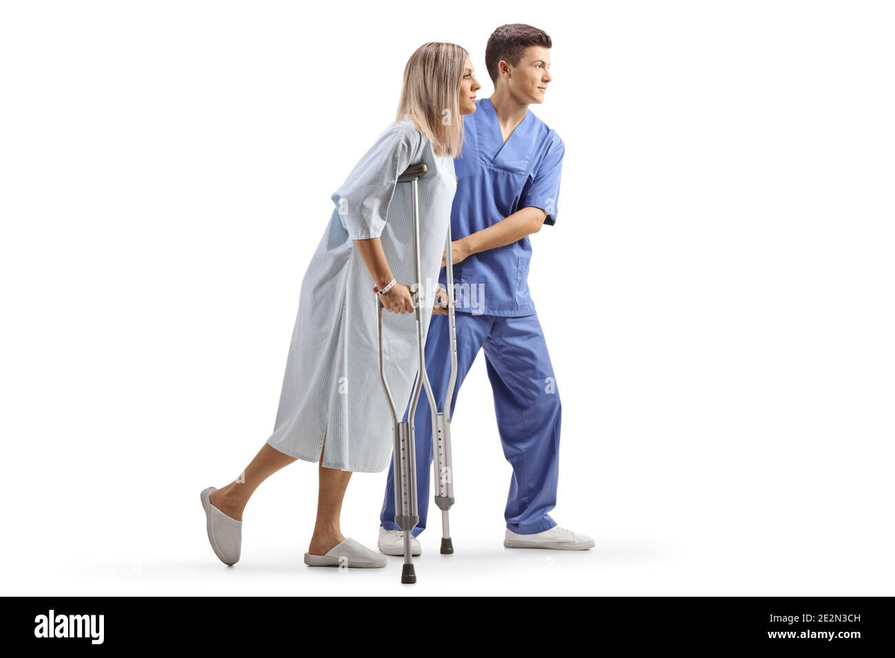 Male doctor helping a female patient with crutches isolated on white background Stock Photo