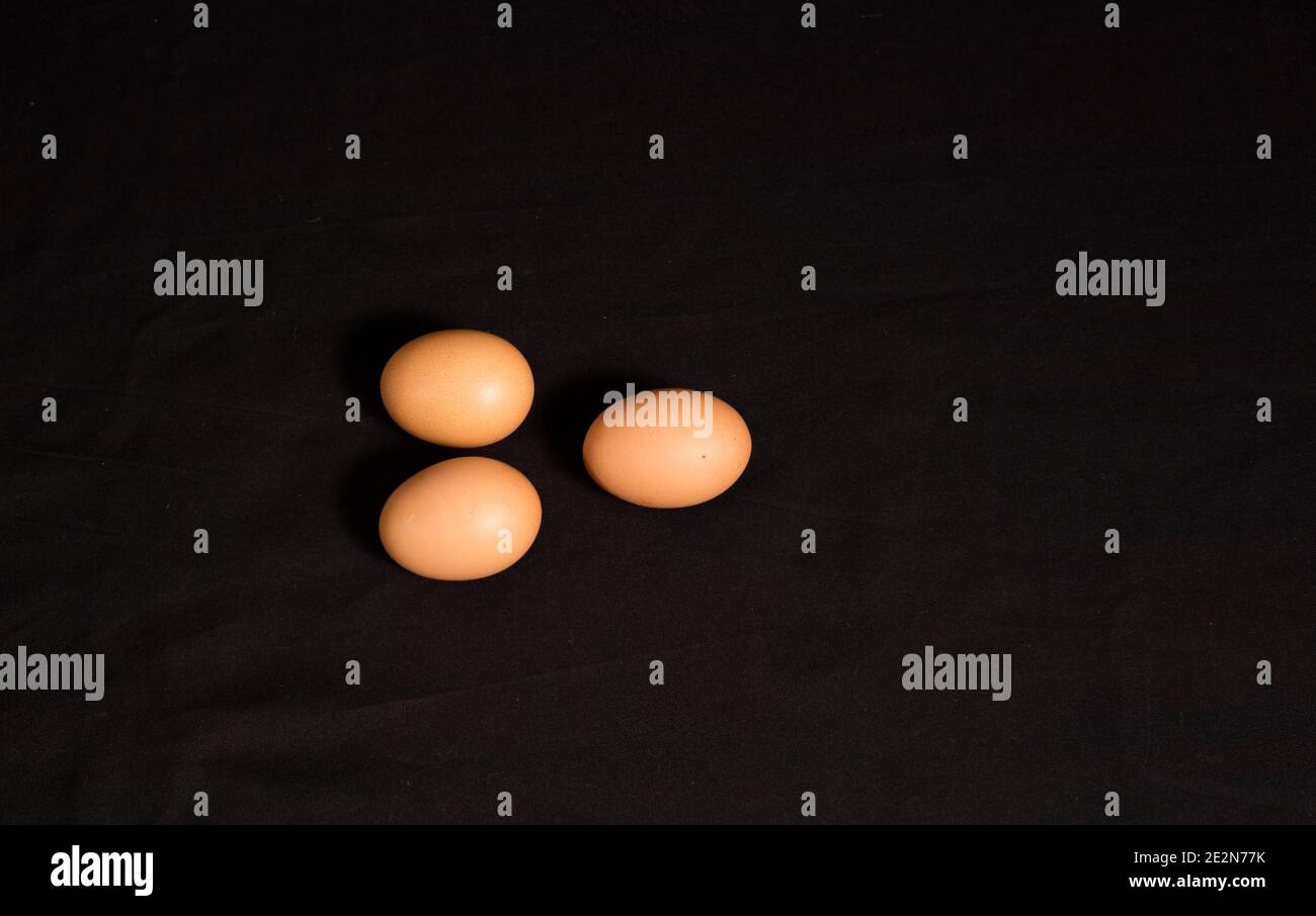 Top view of three brown eggs on a black surface Stock Photo - Alamy
