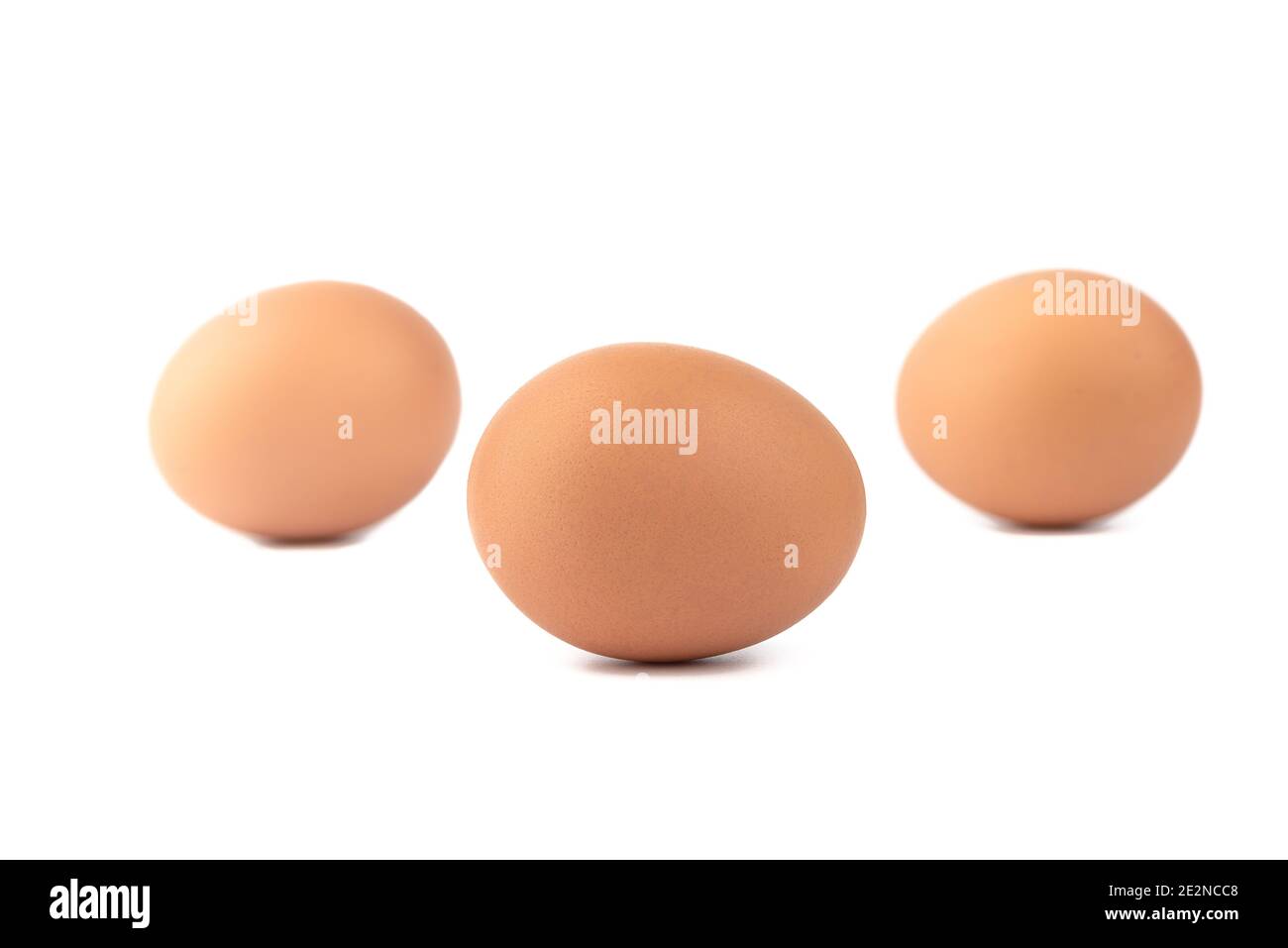Soft focus. Three eggs over a white background. One egg in sharpness the rest are blurred. Stock Photo
