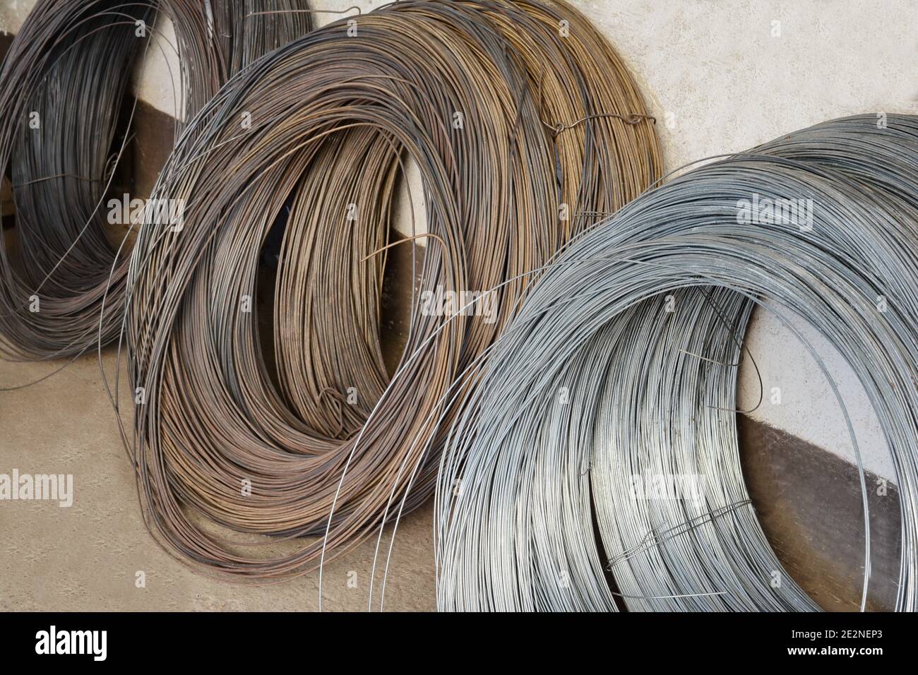 Industry wire roll up in storage. Construction Material Roll of Metal Wire Strands Stock Photo