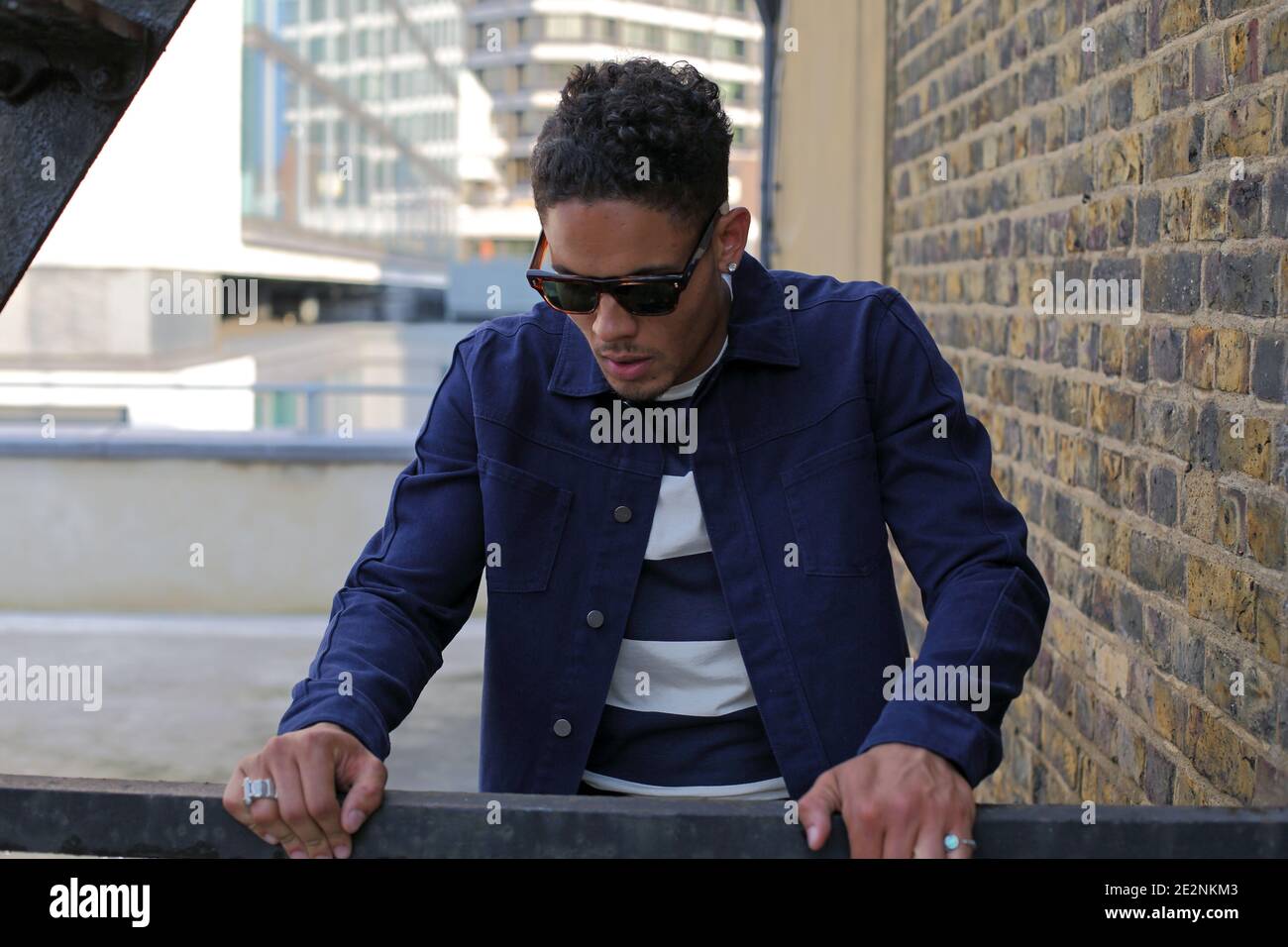 Young man looking down a building . Stock Photo