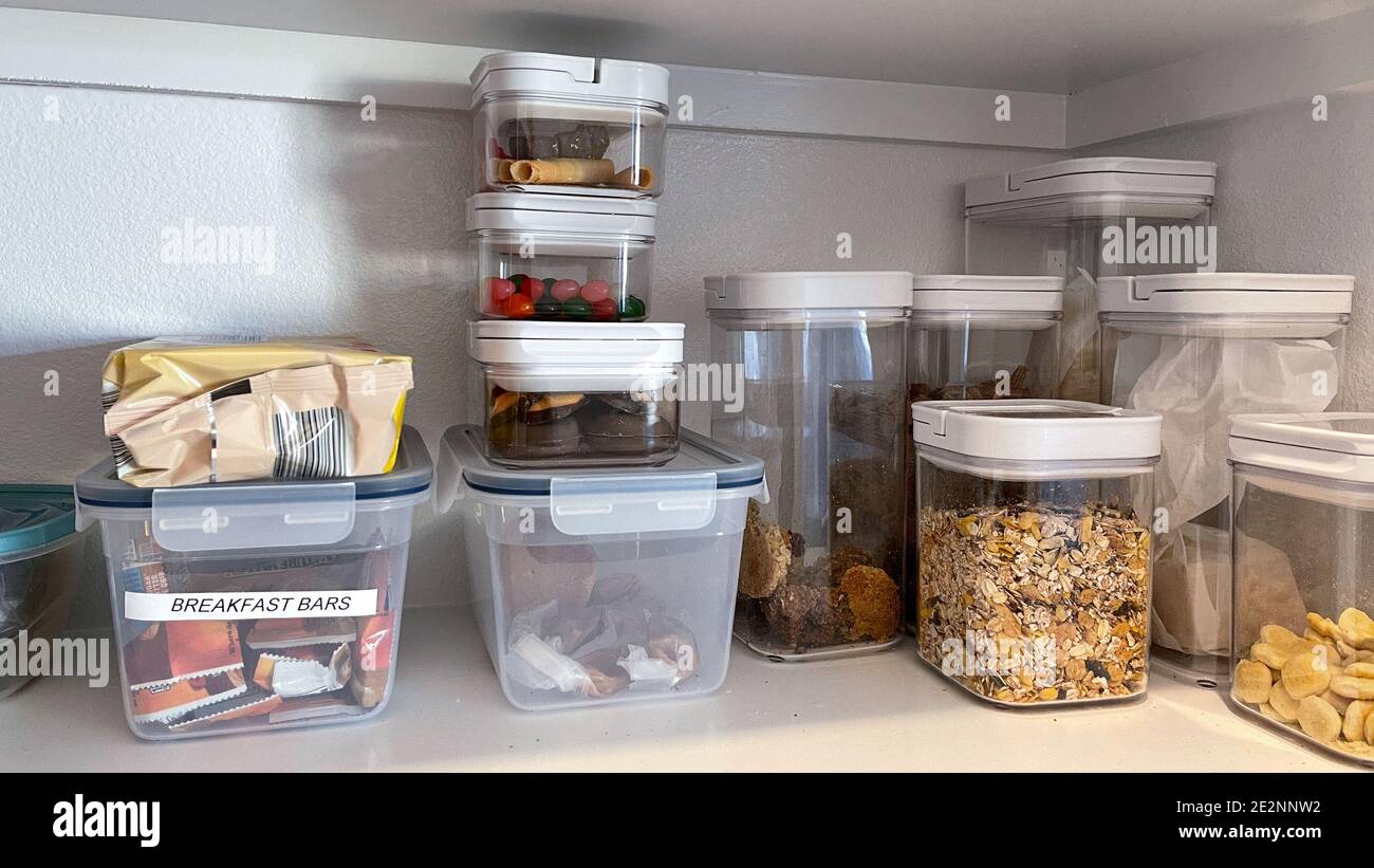 https://c8.alamy.com/comp/2E2NNW2/an-organized-pantry-shelf-with-various-types-of-cookies-cereal-and-snacks-tidily-put-in-plastic-containers-2E2NNW2.jpg