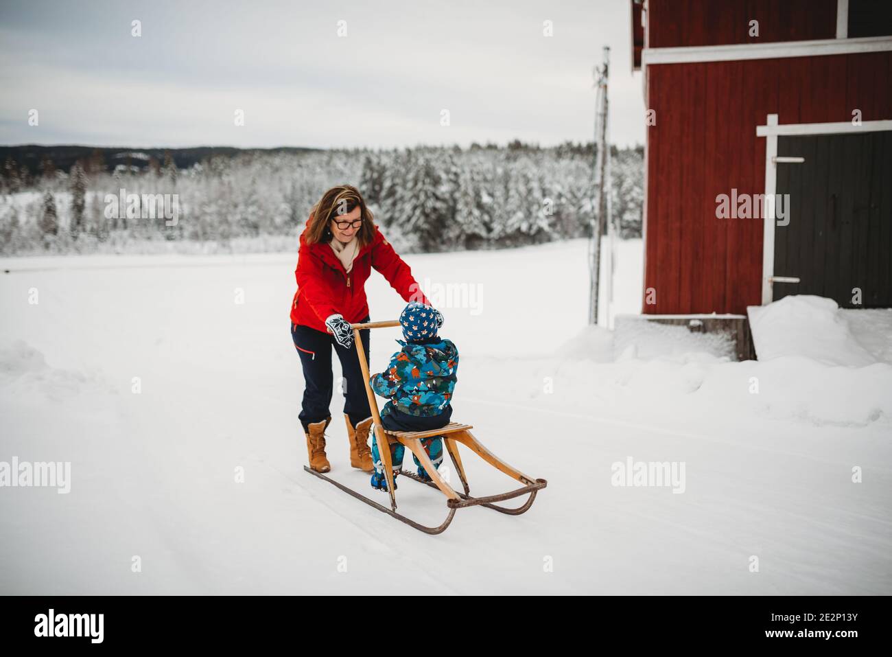 Grandma on old antique sleigh with grandchild in farm in Norway Stock Photo