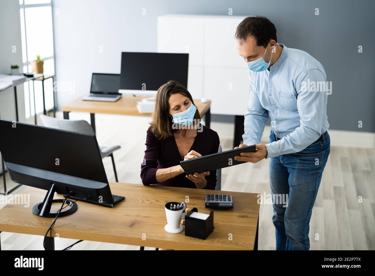 Employee Assistant Training Wearing Face Mask In Office Stock Photo