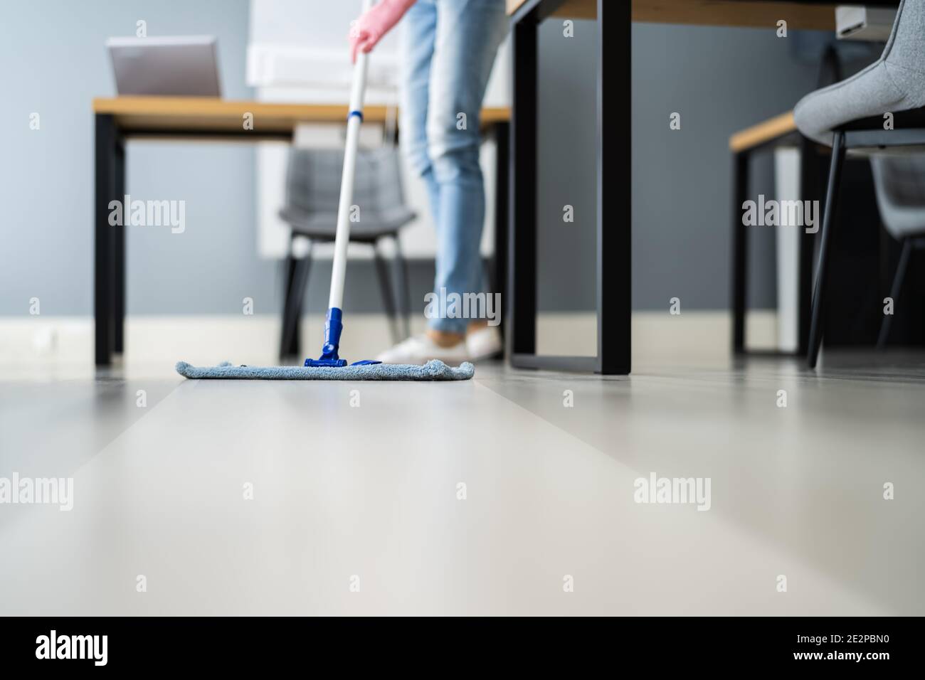 Female Janitor Mopping Floor In Office Or Workplace Stock Photo