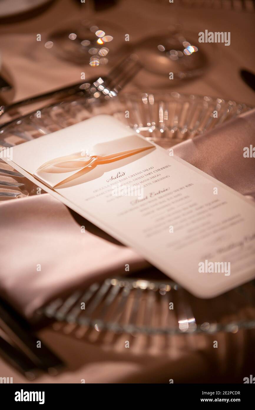 Elegant table setting and decorative menu for a dimly lit wedding party ...
