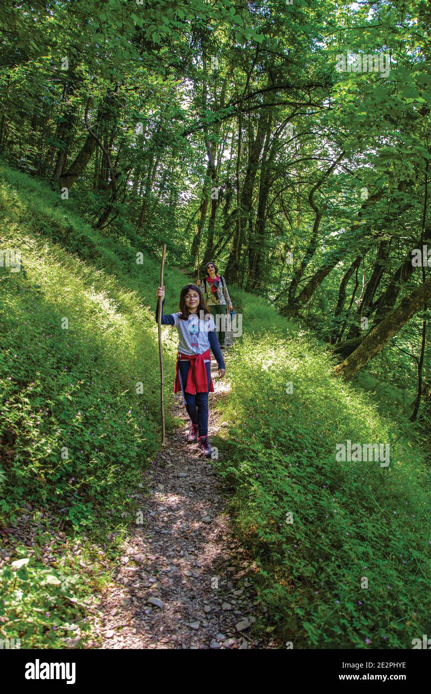 Woman and child walking along dirt pathway in green forest near Saint-Gervais-Les-Bains. A famous ski resort near the Mont Blanc in the French Alps. Stock Photo
