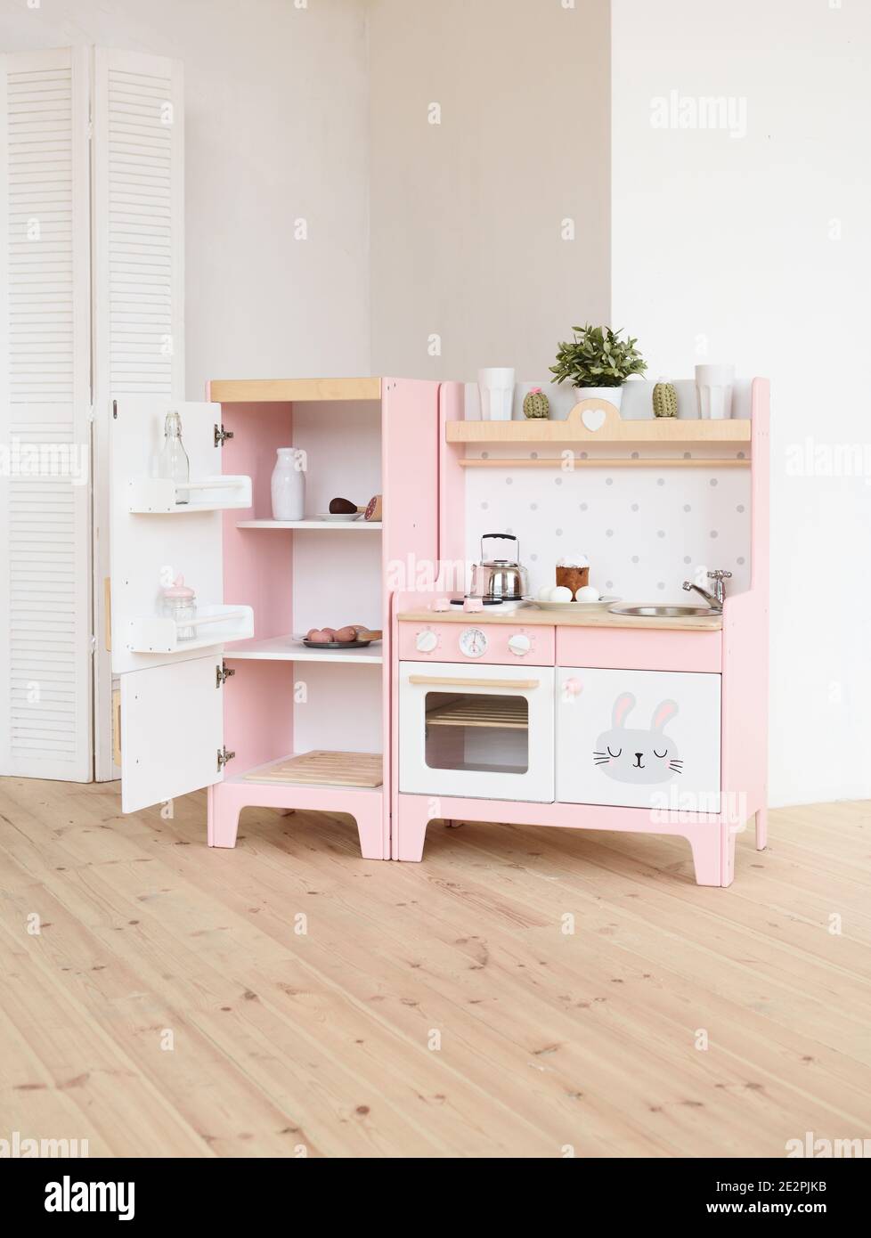 Play furniture for children. Wooden pink and white kitchen with