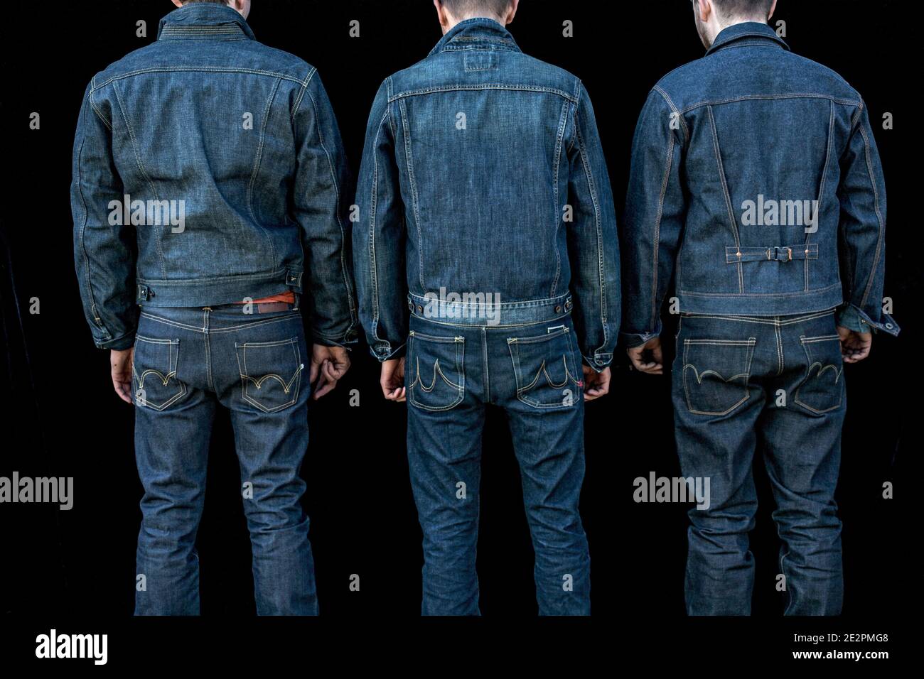 view from behind of three men wearing denim jeans .three man rear view Stock Photo