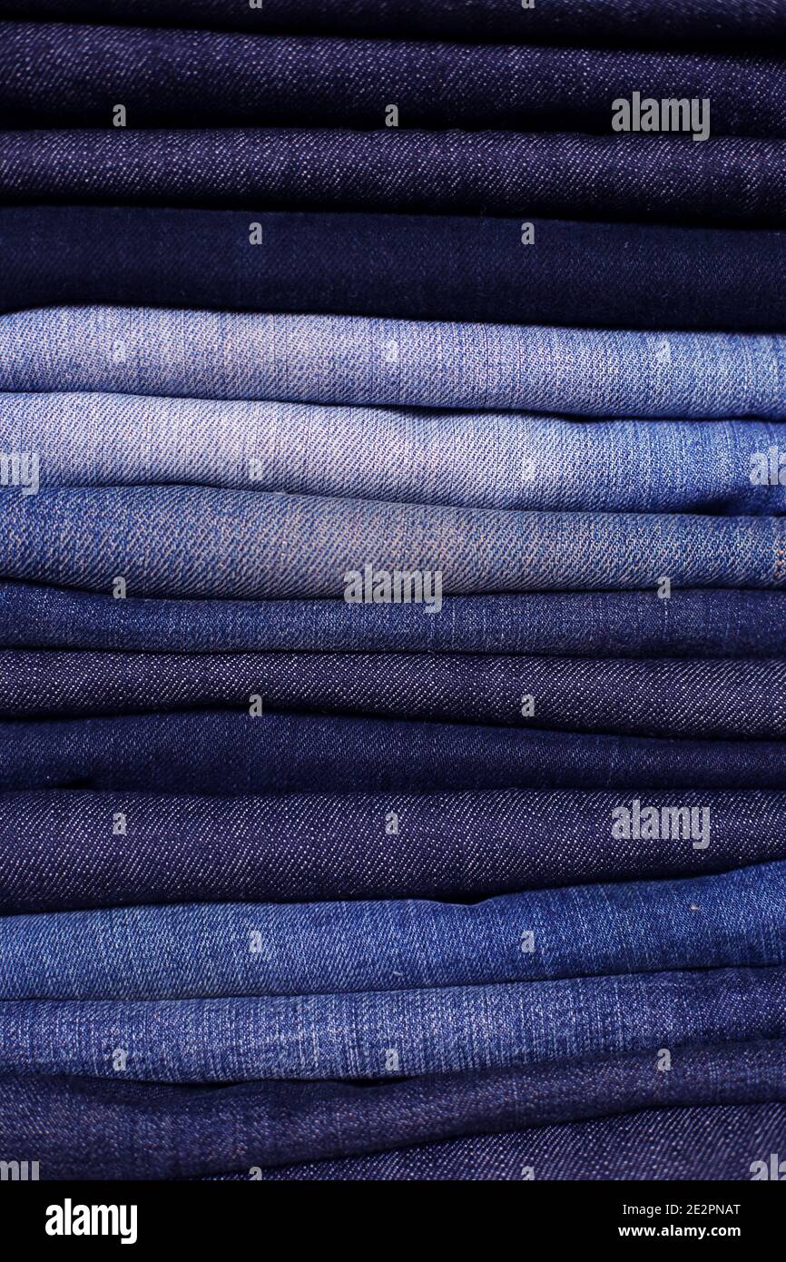 Different shades of blue jeans stacked Stock Photo - Alamy