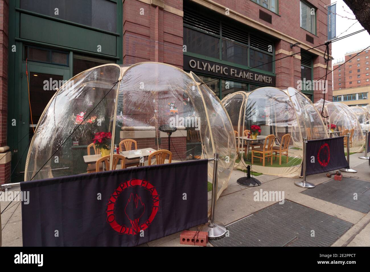 the Olympic Flame Diner in midtown Manhattan with plastic bubble dining pods in front due to dining restrictions for coronavirus or covid-19 pandemic Stock Photo