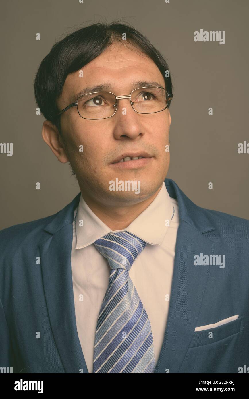 Young Asian businessman against gray background Stock Photo