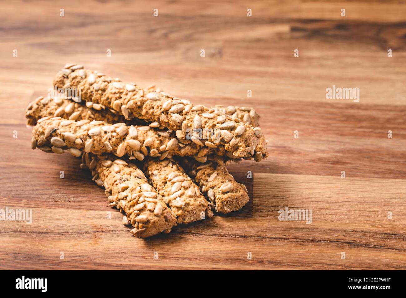 Close up on fresh Crunchy Herbed Whole Wheat Breadsticks multigrain with sunflower seed on wooden table - healthy eating diet organic vegan food with Stock Photo