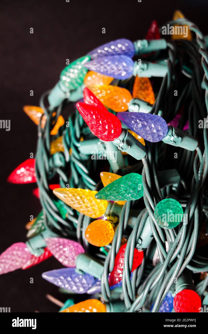Colorful Christmas lights rolled up  on a black background Stock Photo