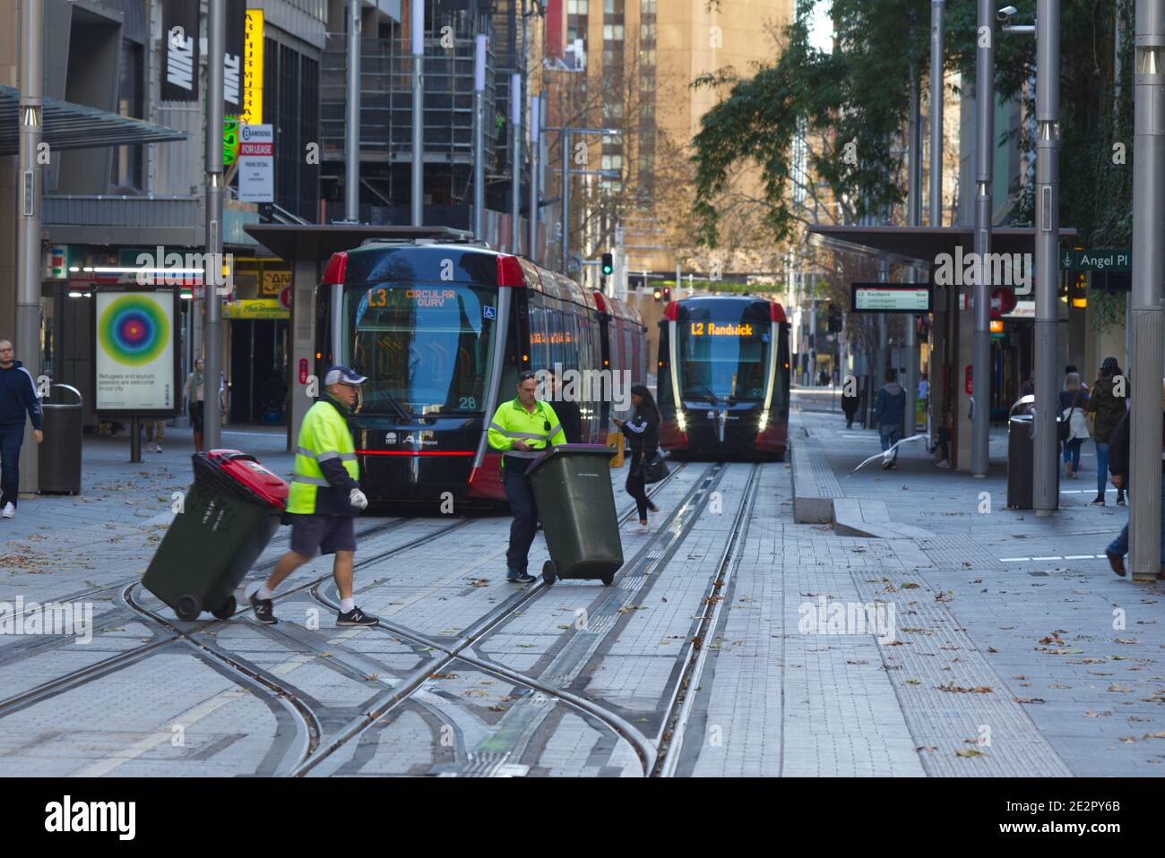 Council workers collecting rubbish in front of Sydney Light Rail public transport system on George Street Sydney Australia Stock Photo