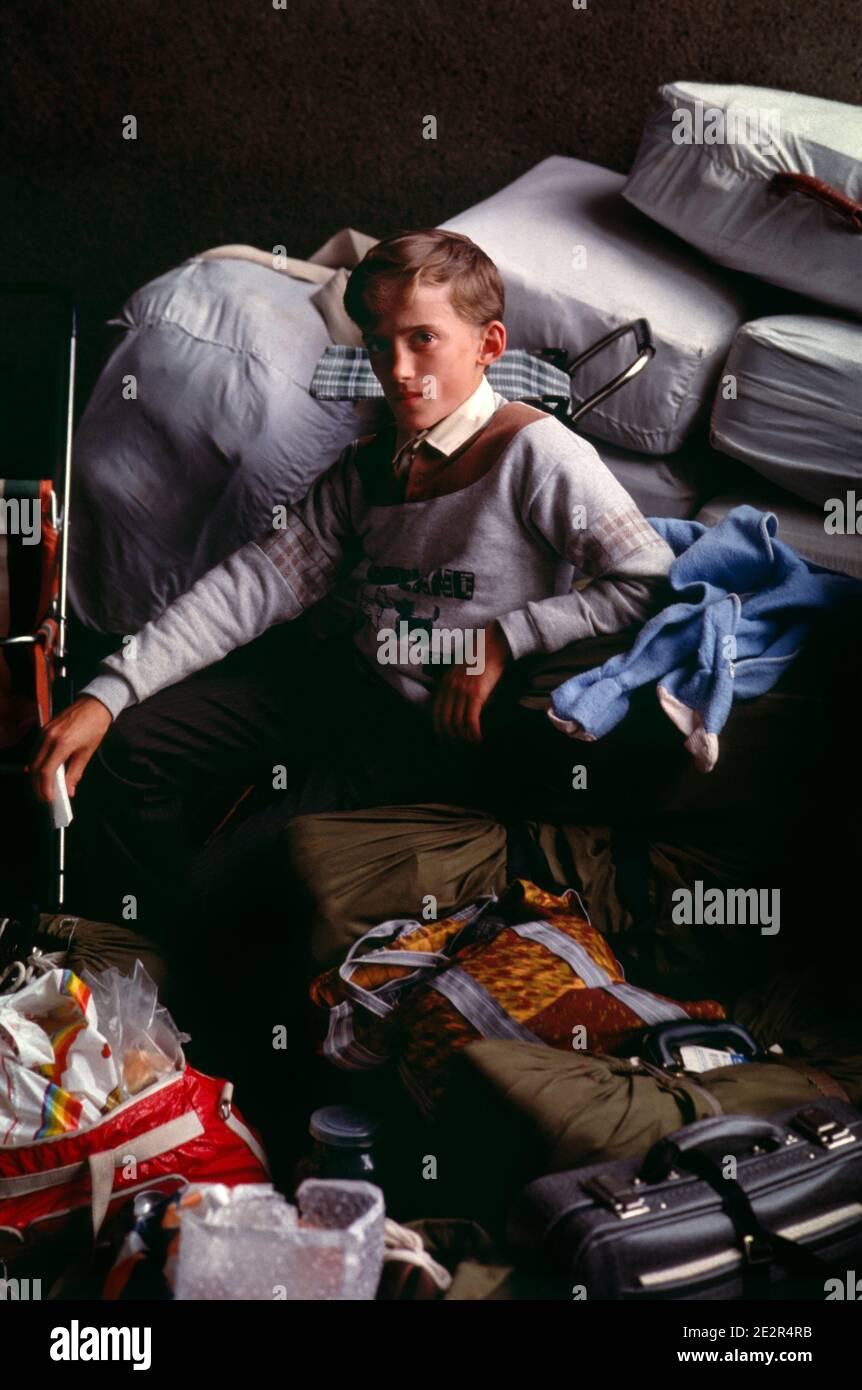 21 May 1991, Sheremetyevo International Airport, Moscow, Russia, USSR. A Russian German teenage boy, with his family, waits with their belongings inside the airport for days for their flight to Germany. Stock Photo