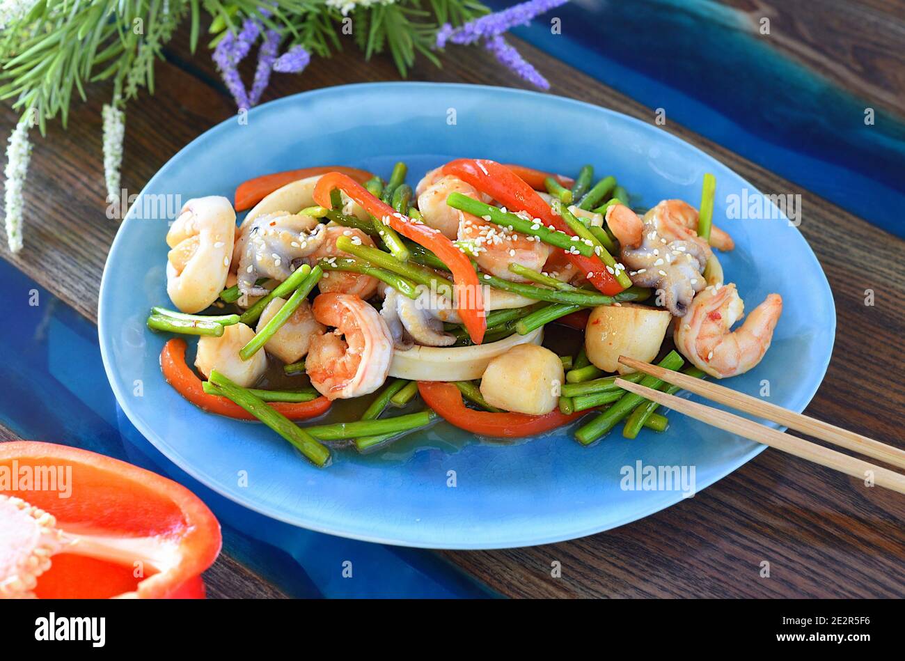 Asian dish with seafood, vegetables in soy sauce on a plate. For asian