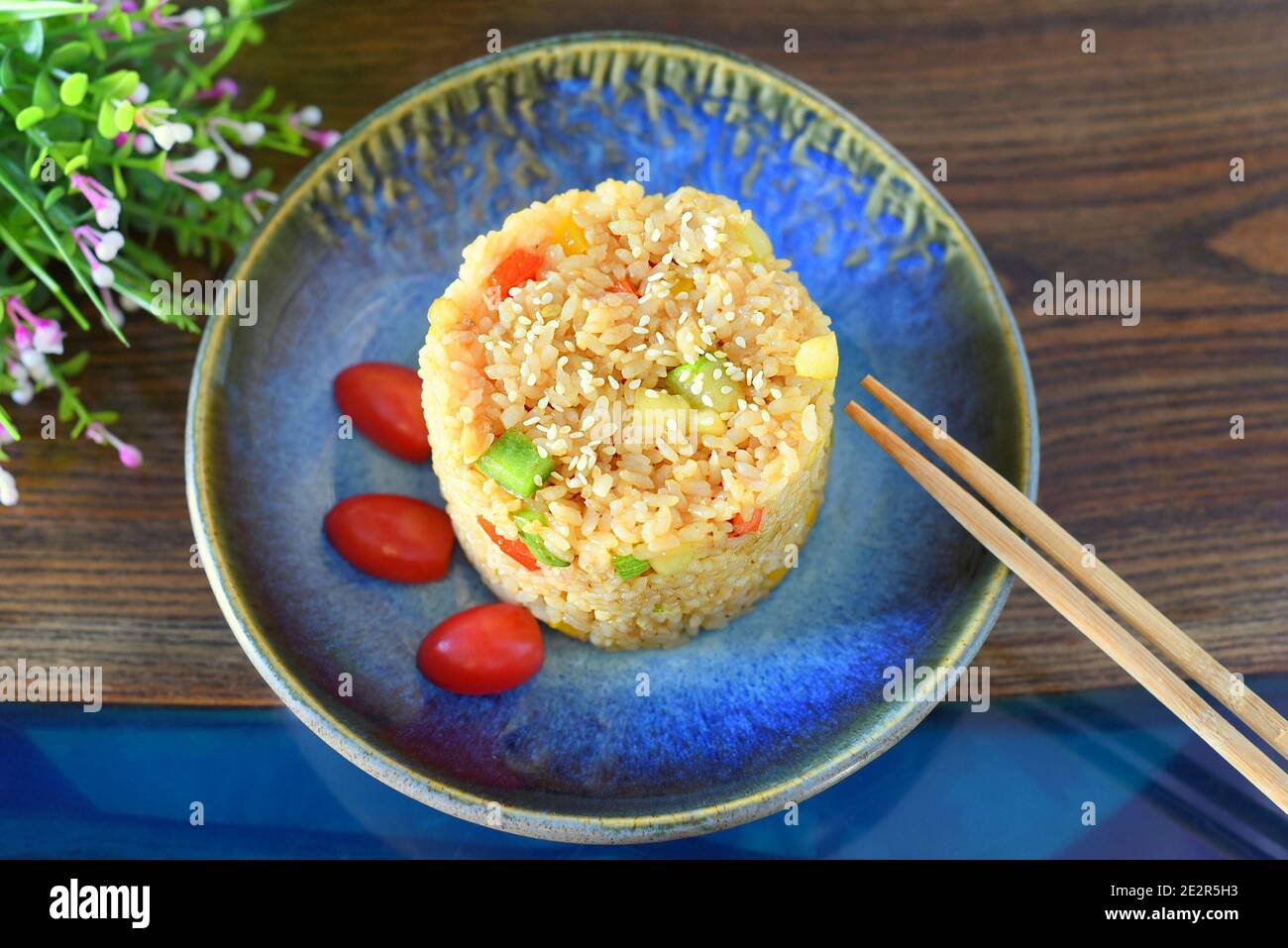 Fried rice with paprika and zucchini garnished with cherry tomatoes. for asian food menu Stock Photo