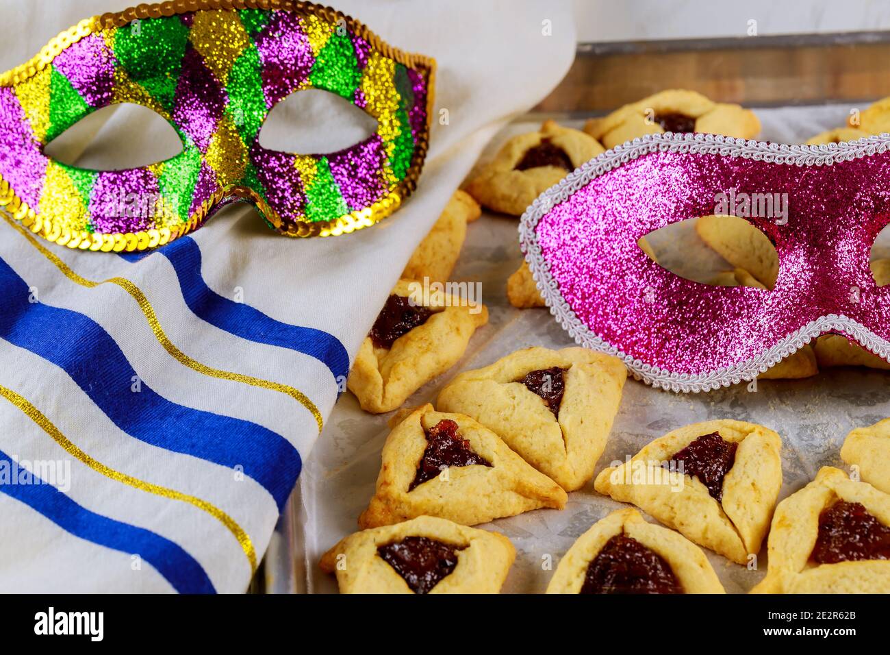 Traditional hamantaschen jewish cookies with jam, tallit and mask for Purim. Jewish holiday