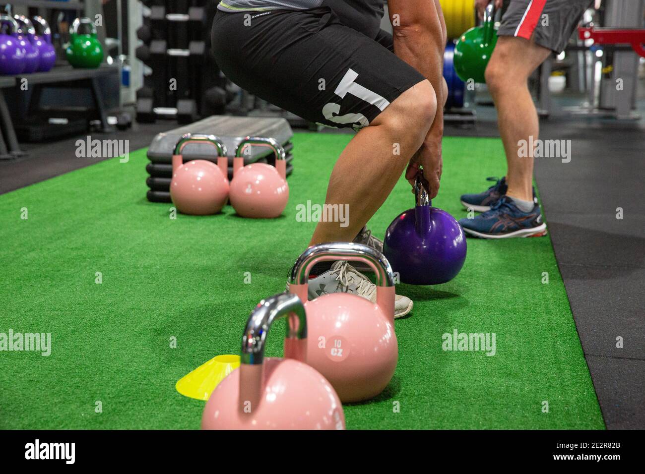 Lifting kettlebell weights in a gym class Stock Photo Alamy