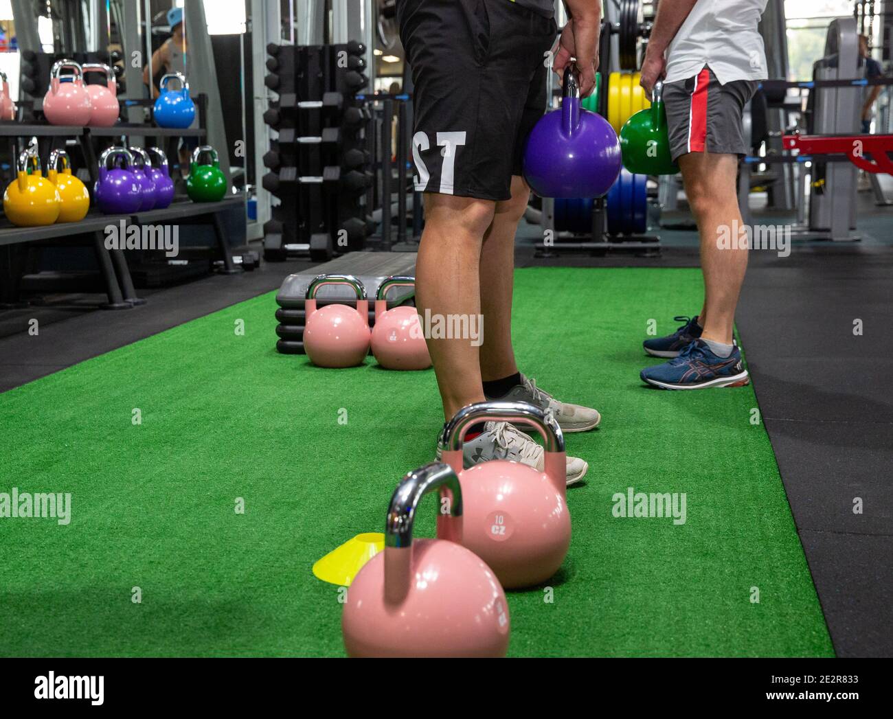 Lifting kettlebell weights in a gym class Stock Photo Alamy