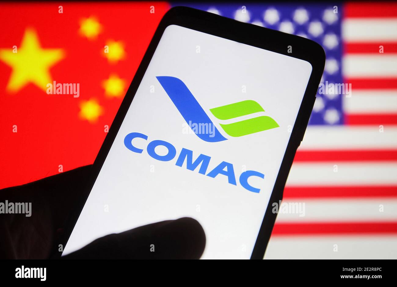 Kiev, Ukraine. 15th Jan, 2021. In this photo illustration, Commercial Aircraft Corporation of China (COMAC) logo is seen on a mobile phone screen in front of flags of the US and China. The administration of US President Donald Trump added Chinese companies including Chinese electronics company Xiaomi to a blacklist, which will be subject to a new US investment ban, reportedly by media. Credit: SOPA Images Limited/Alamy Live News Stock Photo