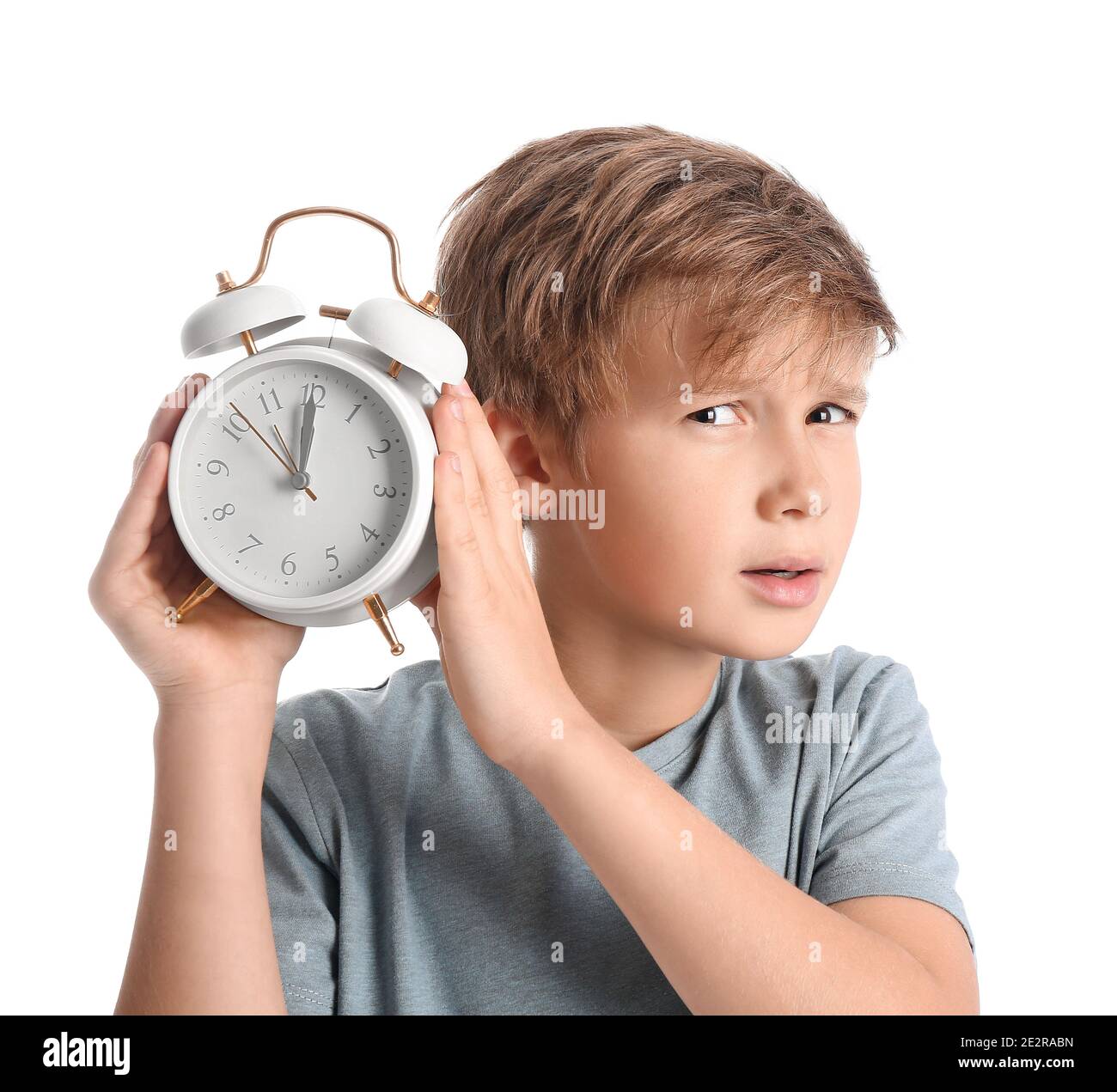 Emotional little boy with alarm clock on white background Stock Photo