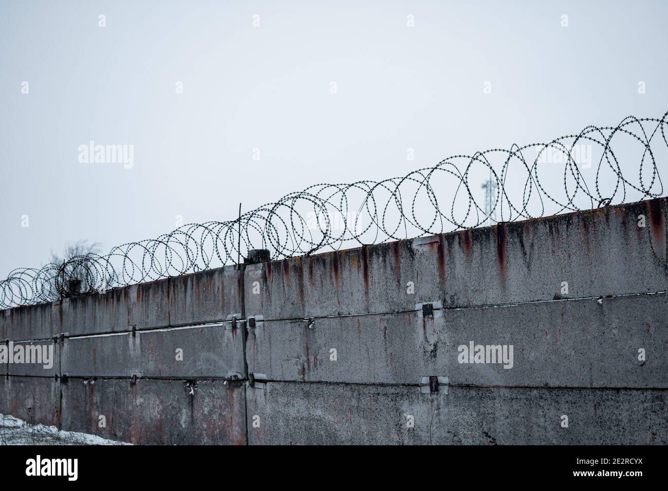 A concrete fence. Barbed wire. restricted area. Stock Photo