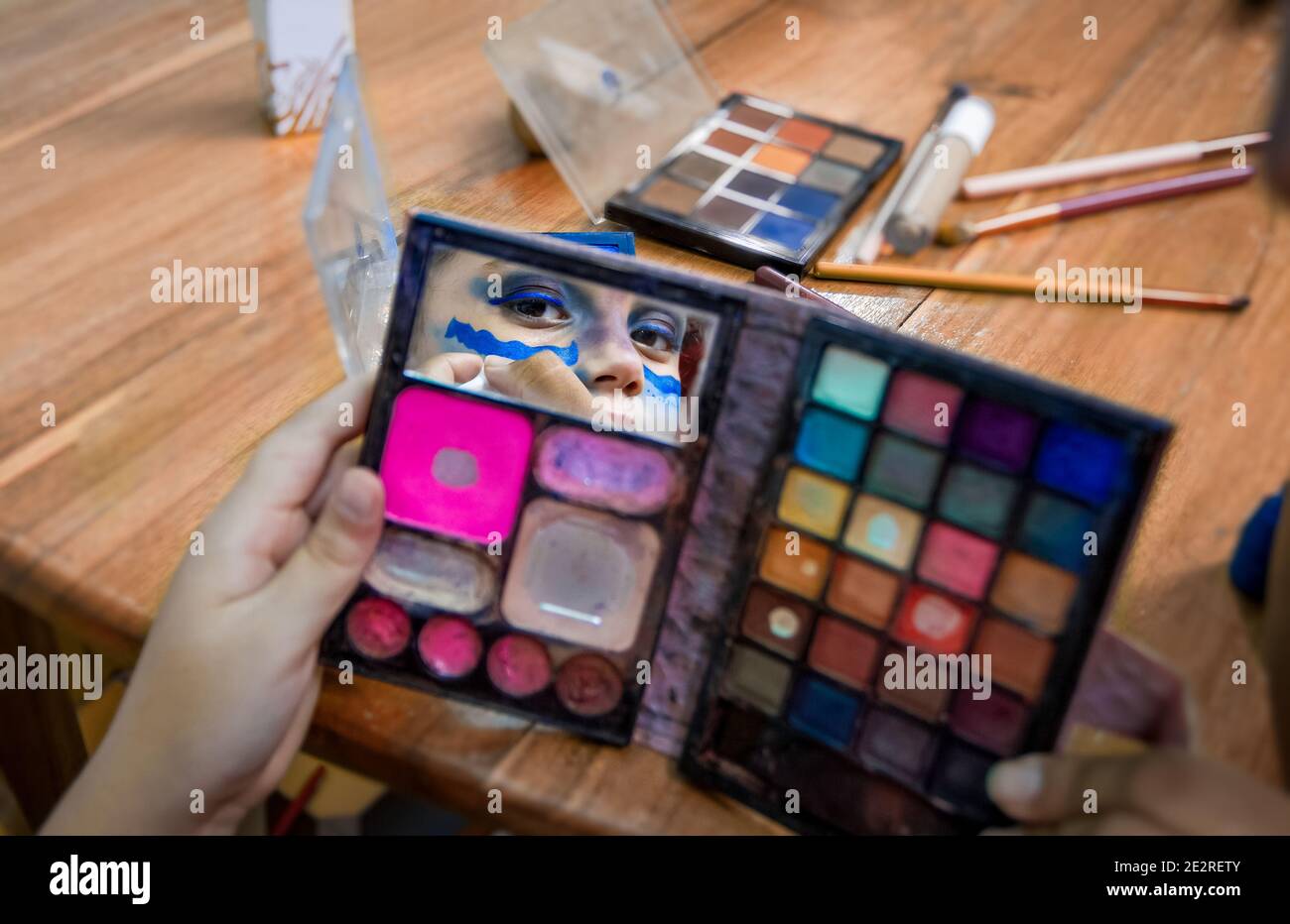 Open makeup case and the reflection of a girl's eyes in the mirror Stock Photo